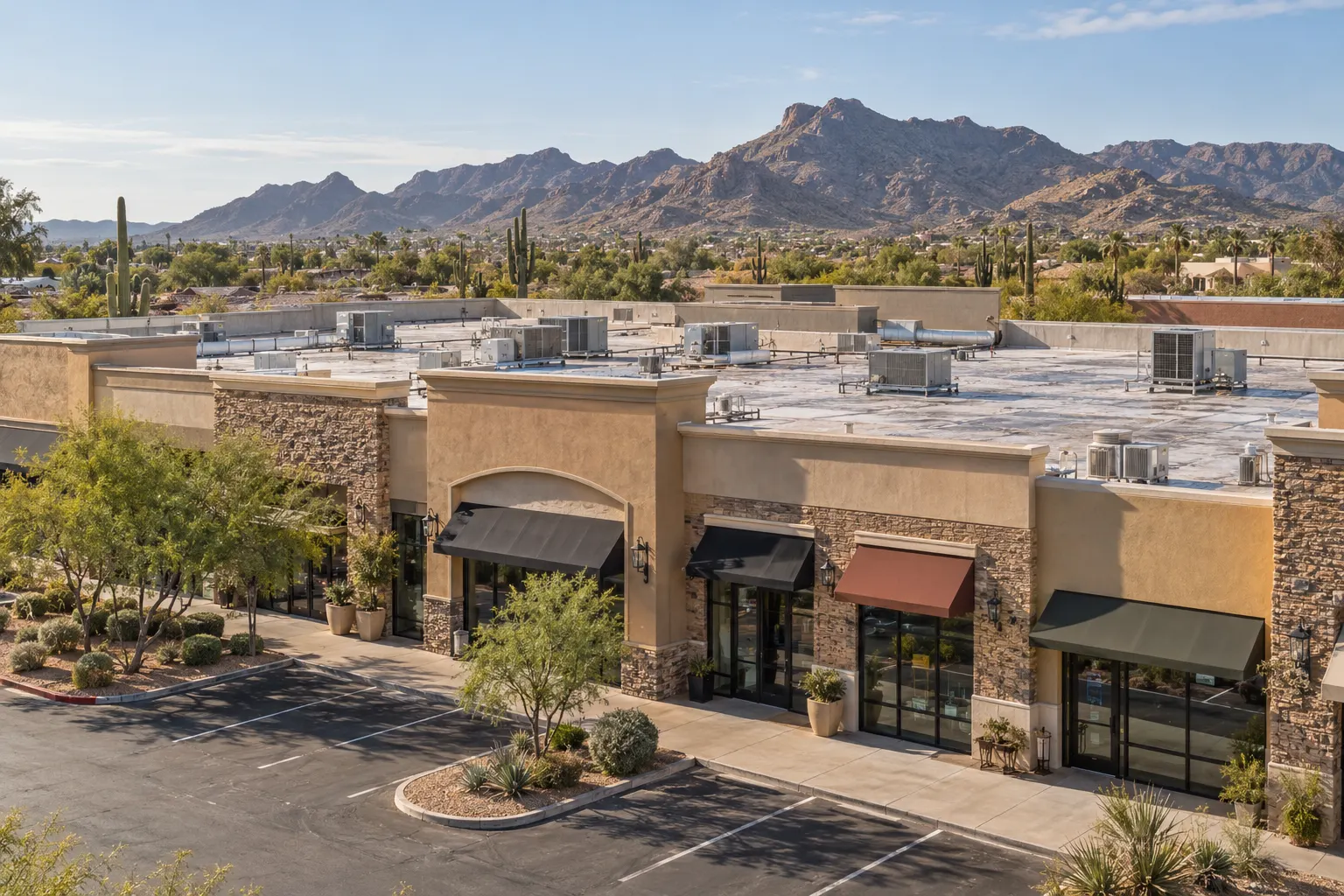 Single-story retail and restaurant strip with awnings and a flat roof crowded with rooftop units